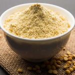 Bowl of besan or gram flour with chick peas around it