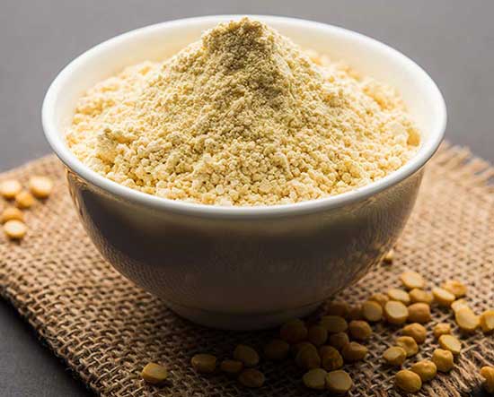 Bowl of besan or gram flour with chick peas around it