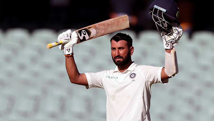 Cheteshwar Pujara lifting his arms up in celebration