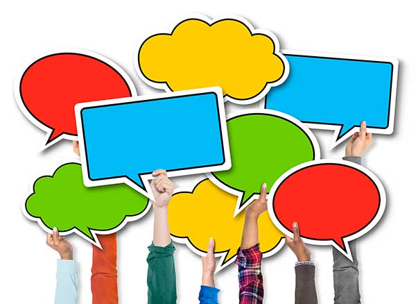 Hands holding up colourful speech bubbles