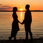 Couple holding hands at sunset