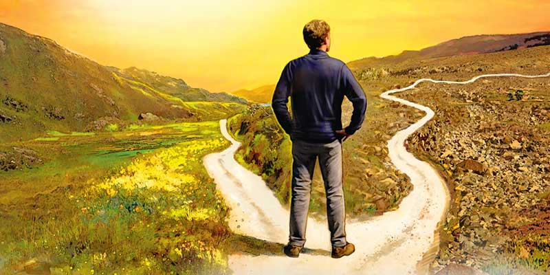 Young man standing at a crossroad