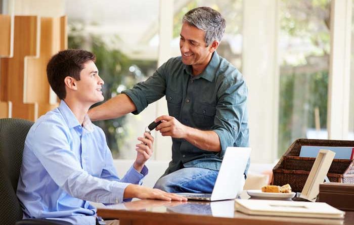 Father giving his car keys to teenage son