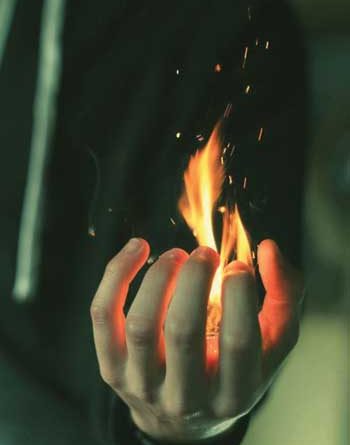Man's fist holding a flame
