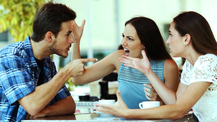 Two female and one male friend arguing at a table
