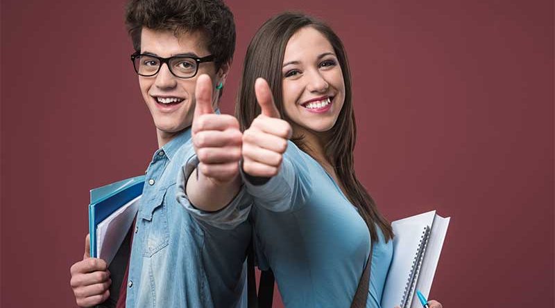 Male and female students giving thumbs up