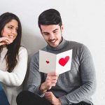 Girl smiling at a boy holding a Valentine's Day card.