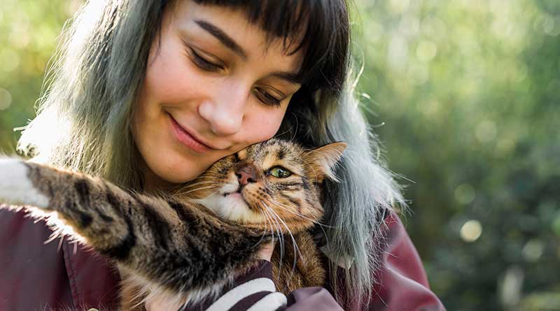 Girl holding a cat close to her face