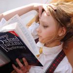 Young girl reading a dictionary