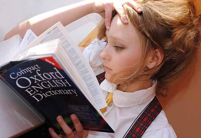 Young girl reading a dictionary