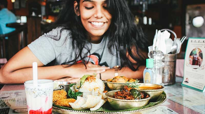 Girl smiling as she looks at her food