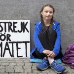 Greta Thunberg sits outside the Swedish Parliament with a banner reading 'School strike for climate'