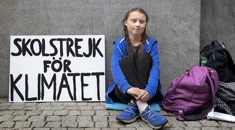 Greta Thunberg sits outside the Swedish Parliament with a banner reading 'School strike for climate'