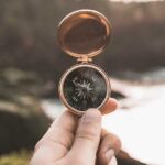 Hand holding up a compass