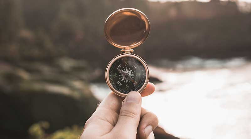 Hand holding up a compass