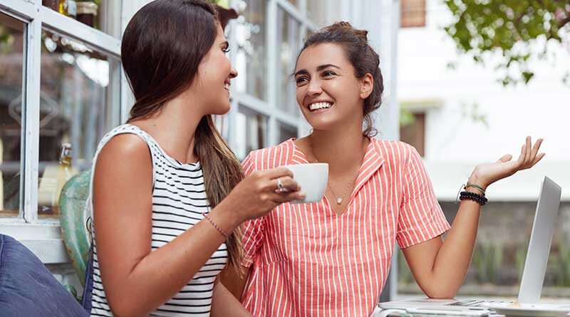 Two happy young women having a pleasant conversation