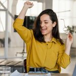 Happy female student with hand in the air