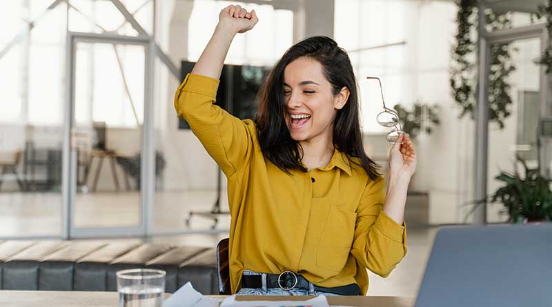 Happy female student with hand in the air