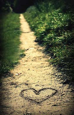 Heart traced on a sandy path