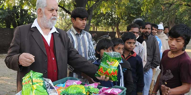 Jagdish Lal Ahuja a.k.a. Langar Bab distributing sweets to children