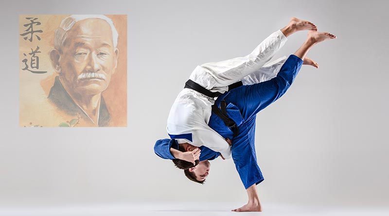 Two judokas fighting; Dr Jigoro Kano's photo in the background