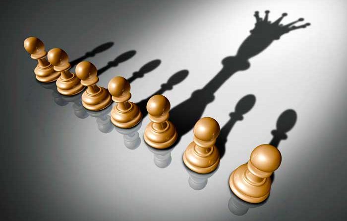 Pawn chess piece casting a shadow of a king chess piece