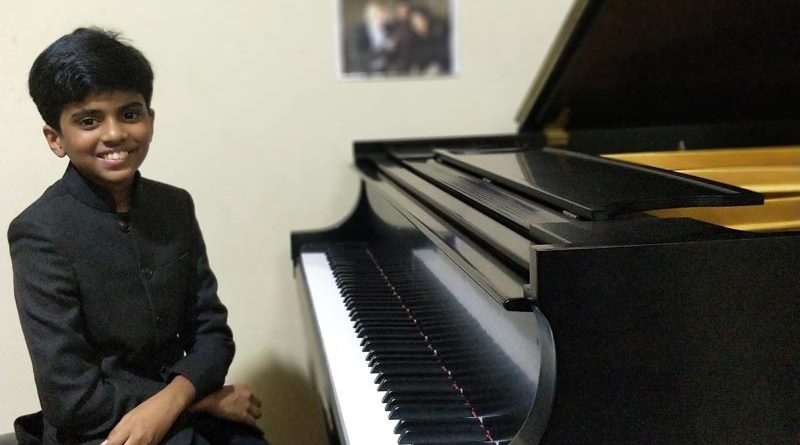 Lydian Nadhaswaram sitting at a baby grand piano