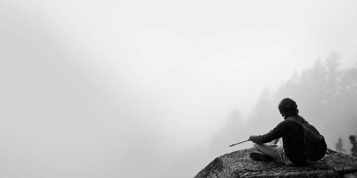 Man sitting on a misty mountaintop