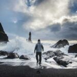 Man walking on seashore in stormy weather