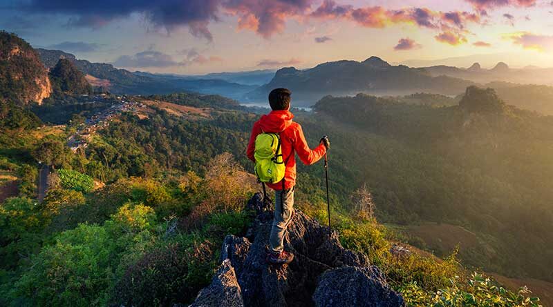 Man trekking to the top of a mountain
