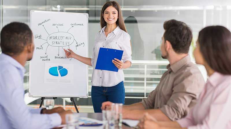 Female media planner giving presentation to teammembers