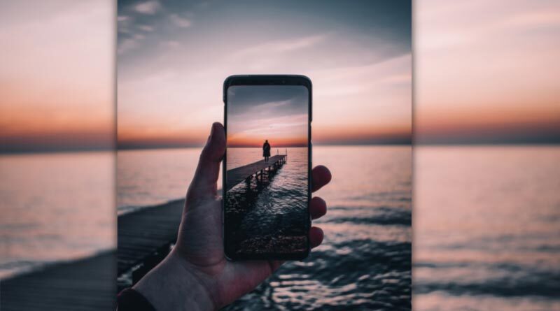 Hand taking a photograph using a mobile phone