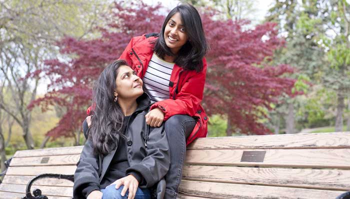 Mother and daughter sitting on a bench outdoors