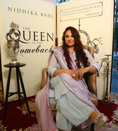 Nidhika Bahl seated in front of her book The Queen Of The Comeback
