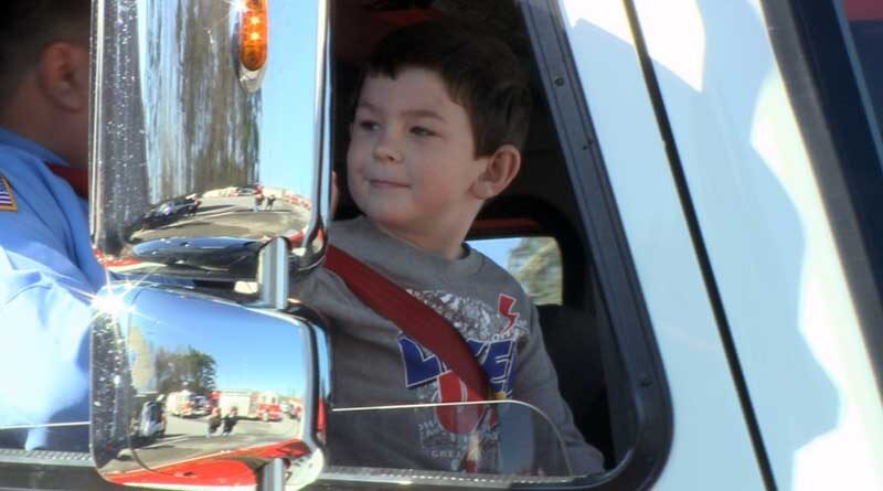 Noah Woods riding in a fire engine