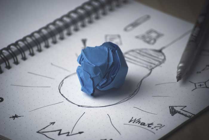 Concept of idea with pen, paper and handdrawn lightbulb
