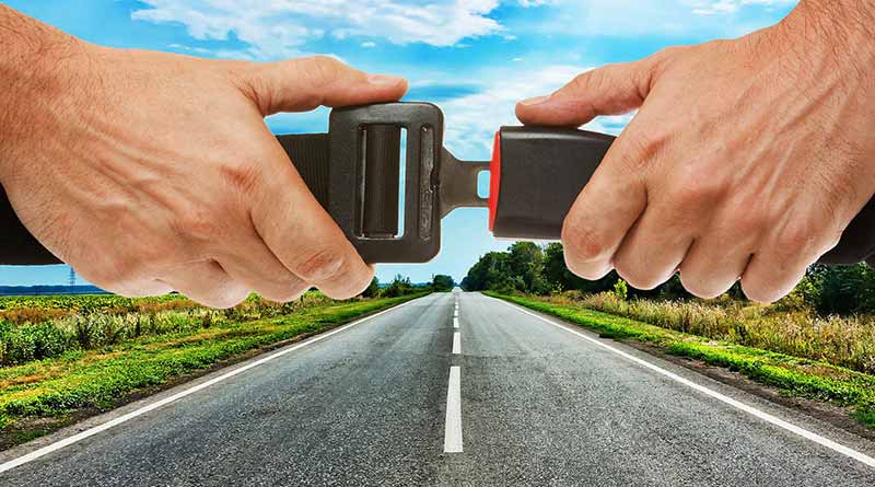 Concept photo of seatbelt being buckled over a road