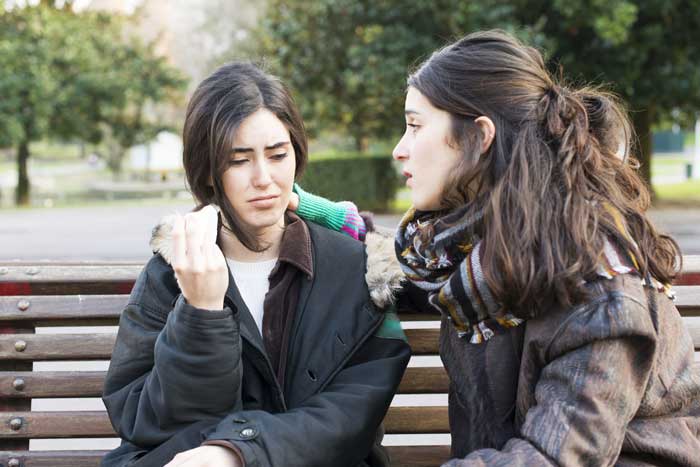 Sad girl being comforted by friend