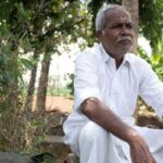 R. Shanmugam sitting near some trees