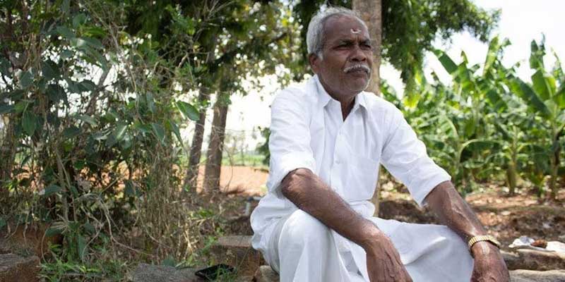 R. Shanmugam sitting near some trees