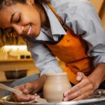 Smiling woman doing pottery using a potter's wheel