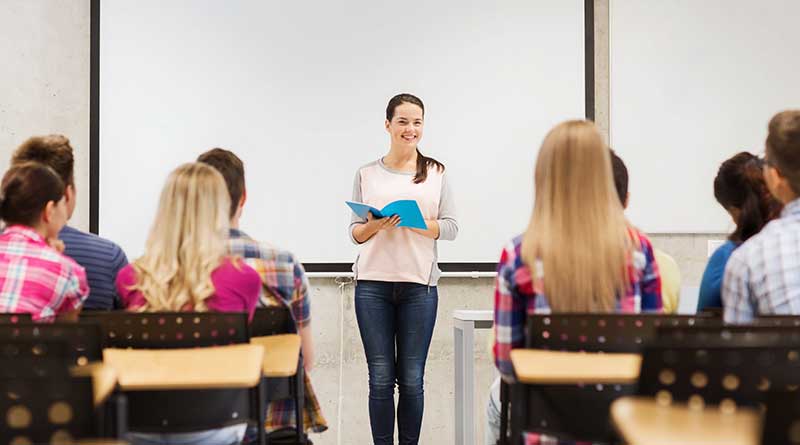 Student standing at the front of a class giving a presentation