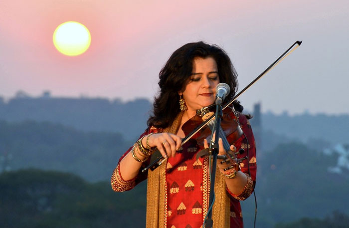 Sunita Bhuyan playing the violin at sunset