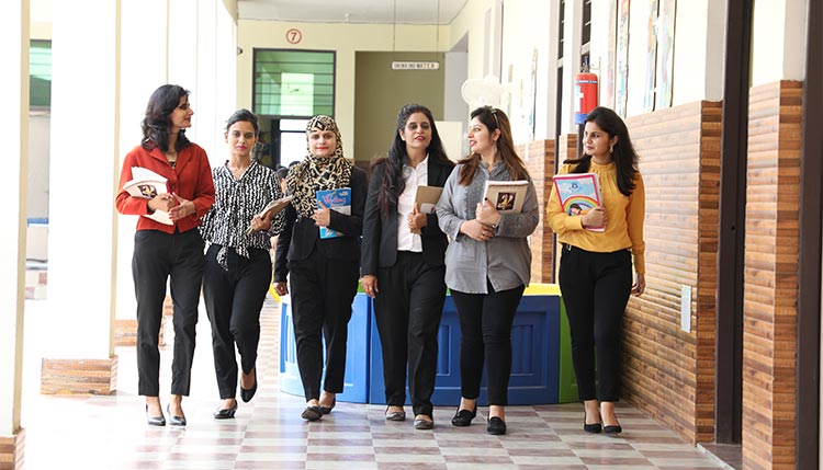 Group of teachers walking down school corridor