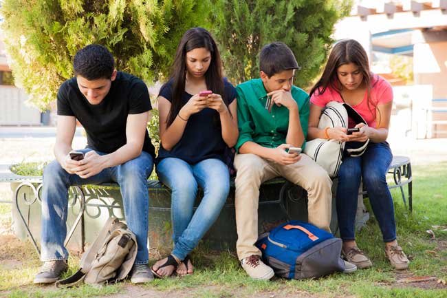 Teenagers on cell phones ignoring each other