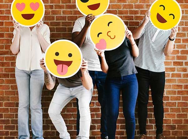Teenagers holding up various emoticons
