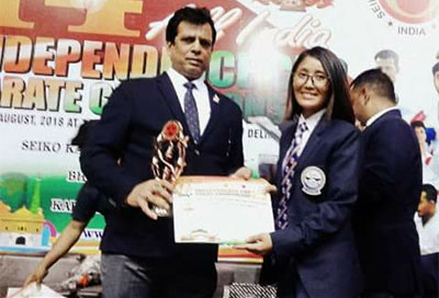 Tshering Yanki Bhuta receives a trophy from Mr Hanshi Bharat Sharma
