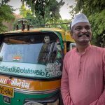 Udaybhai standing near his rickshaw