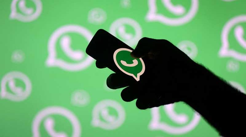 Hand holding phone with WhatsApp symbol on it