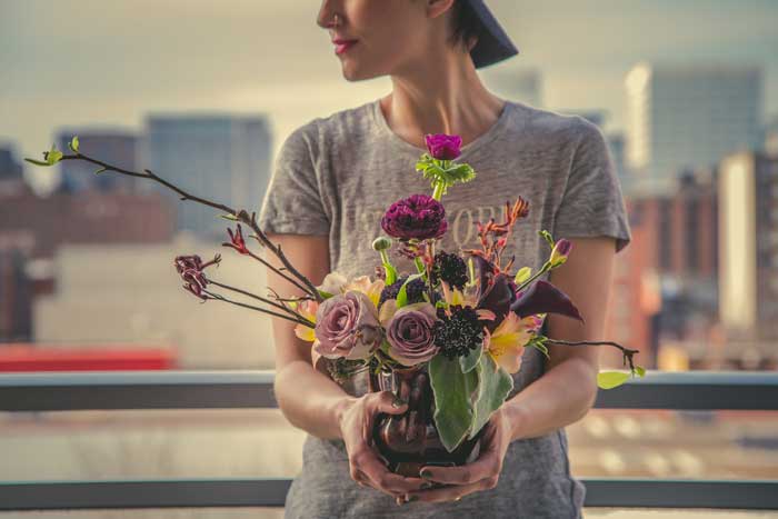 Woman holding flower arrangement
